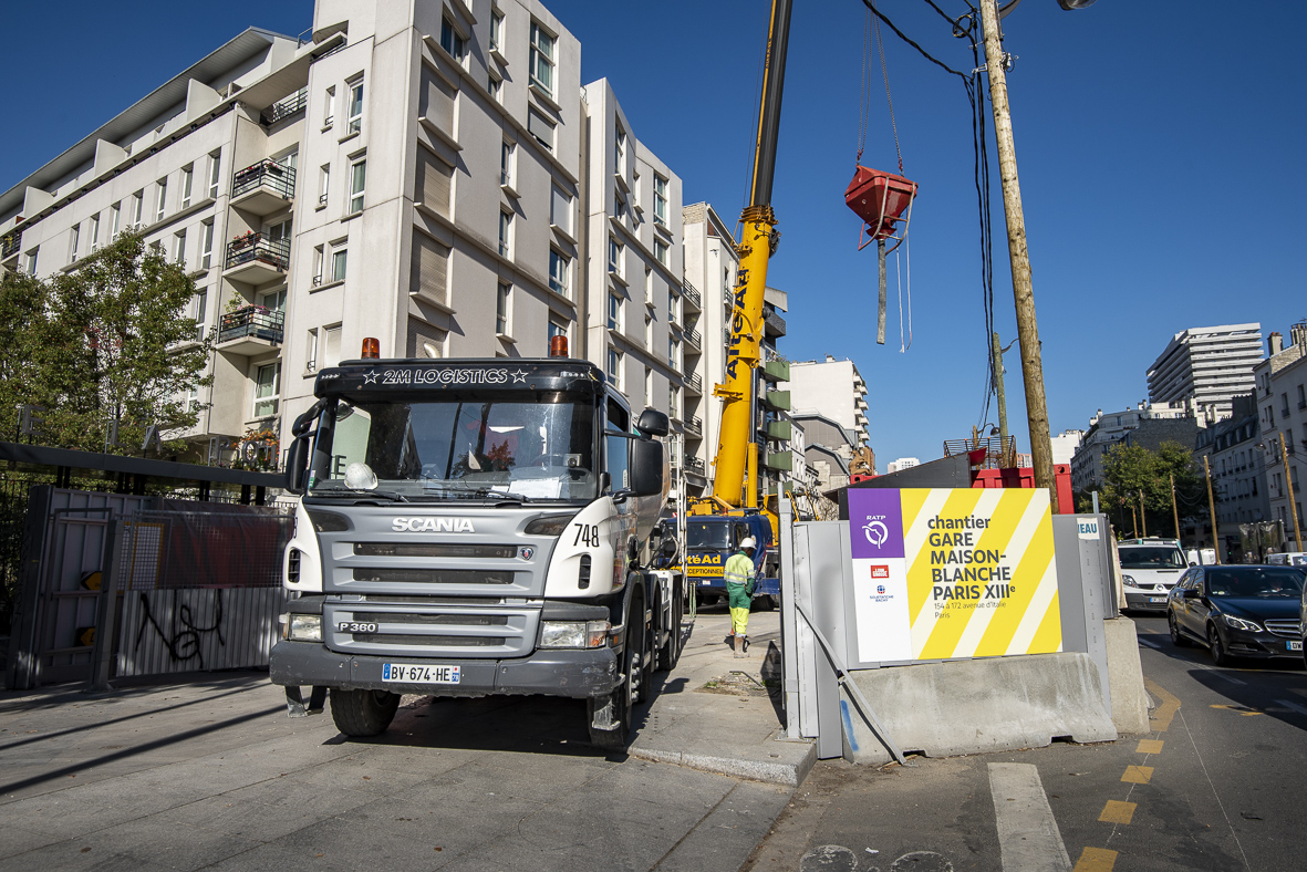 Photo de la sortie d'un camion du chantier de la future gare Maison-Blanche Paris XIIIe sur l’avenue d’Italie