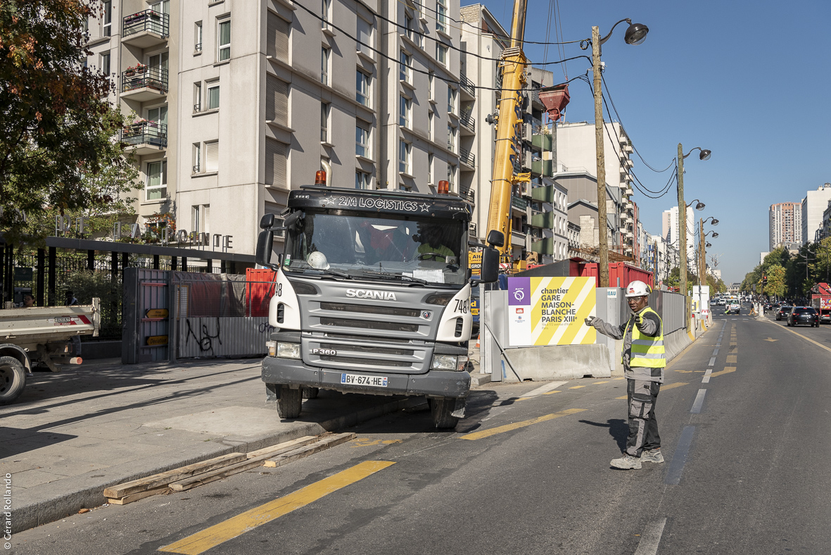 Photographie de la sortie d’un camion du chantier de la future gare Maison-Blanche Paris XIIIe sur l’avenue d’Italie.