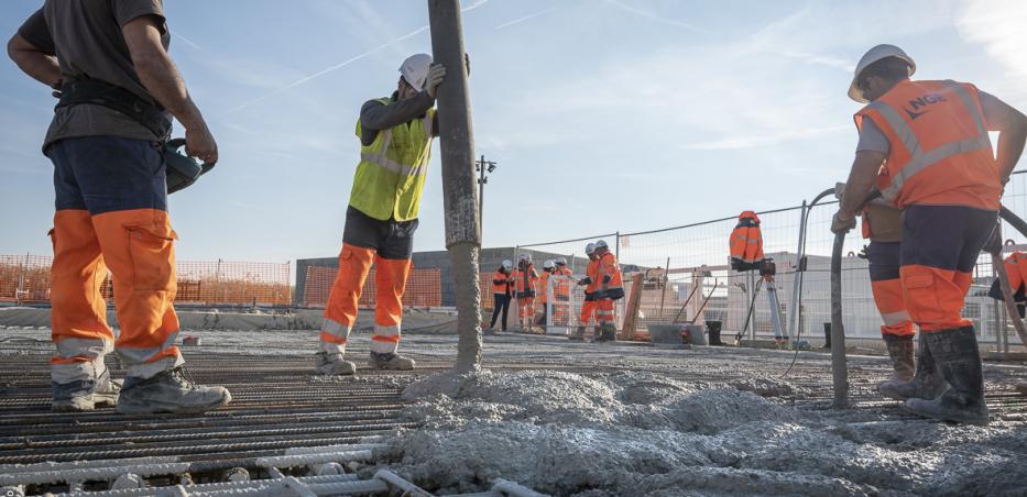 Photo d'ouvriers injectant du béton autour des armatures métalliques sur un chantier de la ligne 14 Sud