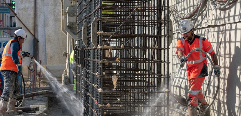 Photo d'ouvriers qui érigent la cage d’armature d’une paroi moulée sur un chantier du Grand Paris Express